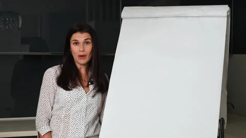 Business coach talking to camera using flipchart Stock Footage 167308908