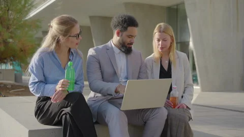 Business Collaboration A Team Engaged in Working on a Laptop While Outdoors in Stock Footage 305724664