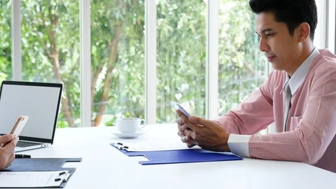 Business colleague working together using smartphone searching website and blogs Видео 124273784