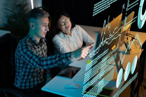 Business Colleagues Analyzing Data on Computer Screen in Office Environment Foto stock