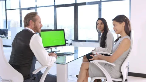 Business colleagues discussing looking at computer with green screen Stock Footage 108204803