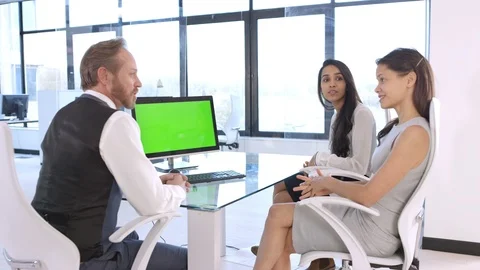 Business colleagues discussing looking at computer with green screen Stock Footage 108205528