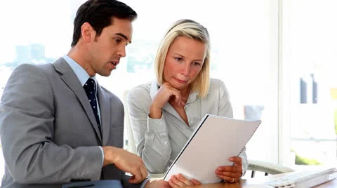 Business colleagues discussing paperwork Stock Footage