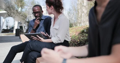 Business colleagues looking at digital tablet outdoors in summer Stock Footage 116324329