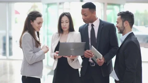 Business colleagues looking at laptop computer and chatting Stock Footage 75169153