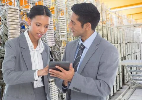 Business colleagues using digital tablet against database server systems in Stock Photos