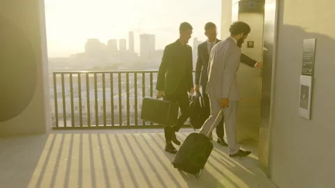 Business Colleagues Waiting for Elevator on Rooftop with Luggage, Engaged in Stock Footage 276347969