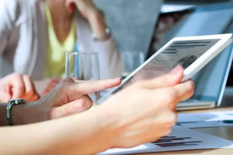 Business colleagues working and analyzing financial figures on a digital tablet Stock Photos