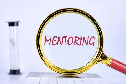 Business concept. The MENTORING concept phrase is written on through a magn.. Stock Photos