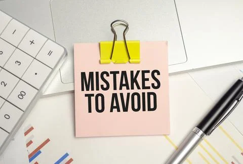 Business concept. Text MISTAKES TO AVOID on notepad and pen Stock Photos