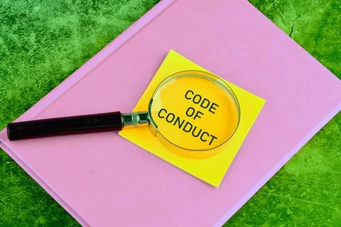 Business concept text. The words CODE OF CONDUCT through a magnifying glass.. Stock Photos