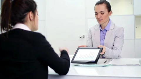 Business consultant explaining something on digital tablet to client HD Stock Footage 10744911