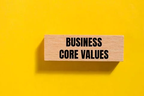 Business core values message written on single wooden block with yellow backg Stock Photos