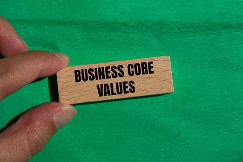 Business core values message written on wooden block with green background. C Foto stock