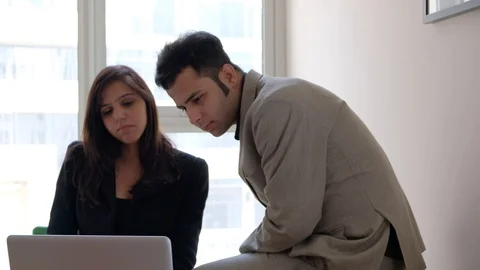 Business couple looking at a laptop computer screen very hard and intently with  Stock Footage 100629423