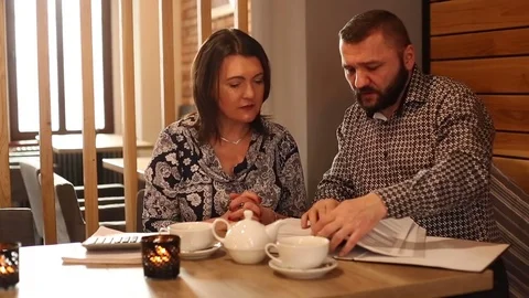 Business couple talking over documents in cafe Video stock 72133576
