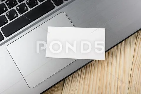 Business credit card over laptop keyboard, making online payment at home, wooden Stock Photos
