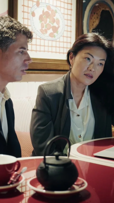 Business discussion between two professionals at a cafe with tea and laptop 库存影片 305982578
