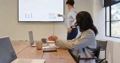 Business diverse professionals analyzing data on laptop during meeting in modern Stock Footage 315950483