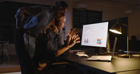 Business diverse professionals analyzing data on laptop in office during night Stock Footage 315966874