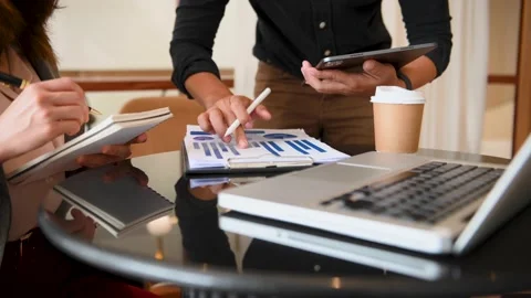 Business documents on office table with smart phone and laptop and two collea Stock Footage 200868861