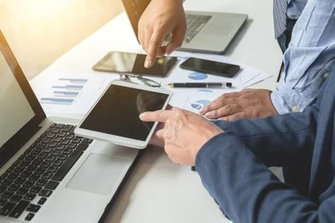 Business documents on office table with smart phone and digital laptop and gr Stock Photos