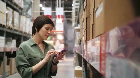 Business e-commerce concept. Young staff checking the goods standing in the Stock Footage 142086333
