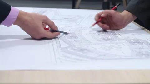 Business engineers discussing a plan to build using drawings Stock Footage 87085722