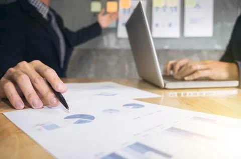 Business executive pointing graph presentation to colleagues in office, durin Stock Photos