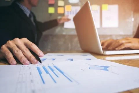 Business executive pointing graph presentation to colleagues in office, durin Stock Photos