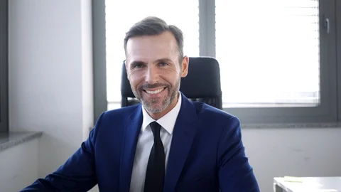 Business executive working in office with computer and then looking at camera Stock Footage 114813937