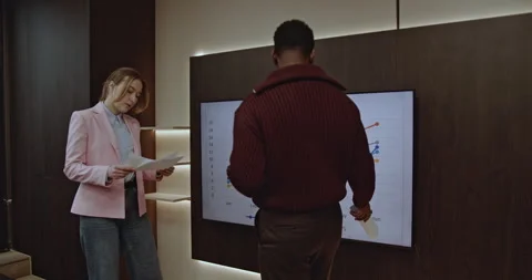 Business Executives Analyze Growth Chart Data on Screen, Discussing Performance Stock Footage 314136739