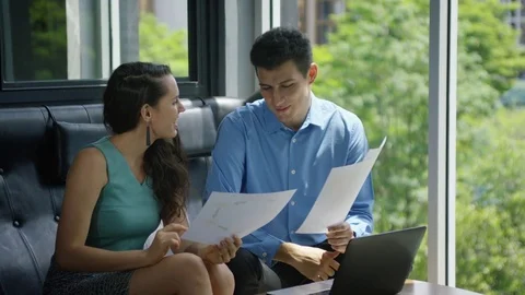 Business executives discussing over document in office Stock Footage 75451343