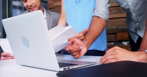 Business executives discussing over laptop Stock Footage