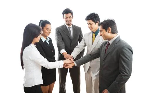 Business executives stacking their hands and smiling Stock Photos