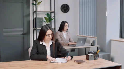 Business girl in eayglasses makes a note in office Video stock 237329550