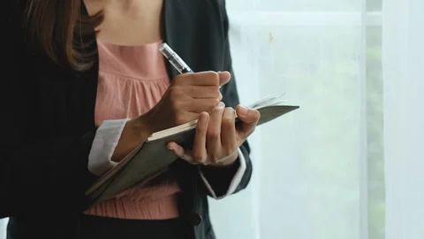 Business girl write something on notebook then lean to glass windows Stock-Footage 122120406