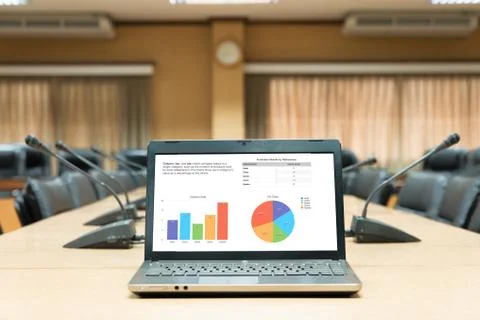 Business graph laptop computer placed on wooden meeting table in empty meetin Stock Photos