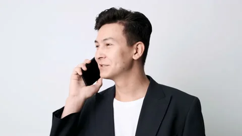 Business guy in an blazer on a white background talking on a cell phone Stockbeeldmateriaal 162192383