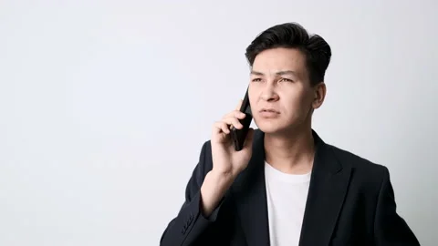 Business guy in an blazer on a white background talking on a cell phone Stockbeeldmateriaal 162192437