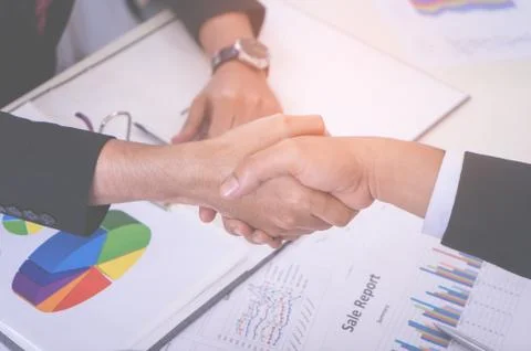 Business hand shake with Data Chart sheet on meeting table 库存照片