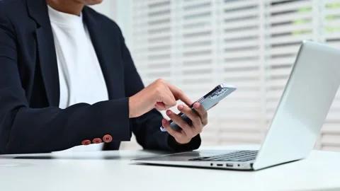 Business hands using smartphone at office desk with laptop. Perfect for the.. Stock Footage 312773565