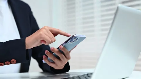 Business hands using smartphone at office desk with laptop. Perfect for the.. Stock Footage 312773572