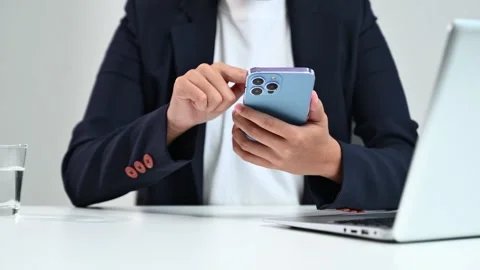 Business hands using smartphone at office desk with laptop. Perfect for the.. Stock Footage 312773573