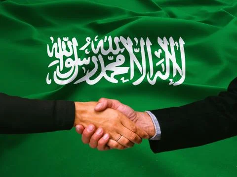Business handshake on Saudi Arabia flag background Stock Photos