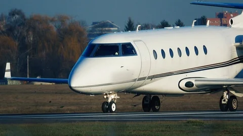 Business jet (private jet) taxiing on the runway after landing at sunset Stock Footage 122079071