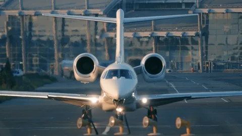 Business jet (private jet) is taxiing on the taxiway before taking off at sunset Stock Footage