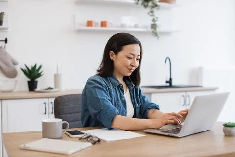 Business lady checking email via computer in kitchen 写真素材