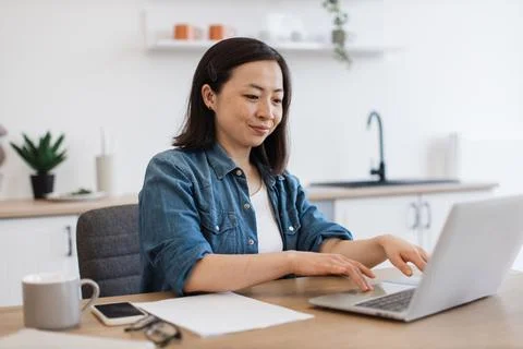 Business lady checking email via computer in kitchen 写真素材