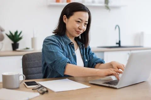 Business lady checking email via computer in kitchen Foto stock